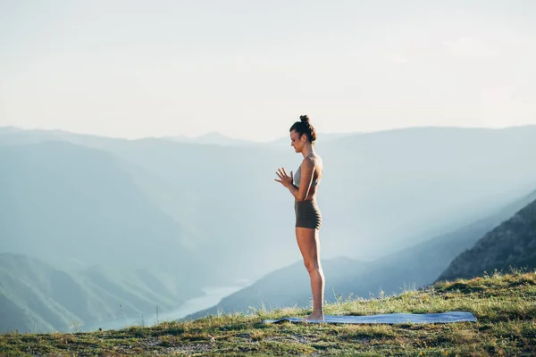 Gün batımında yoga yapan zinde bir genç kız.