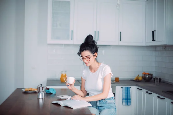 美丽的年轻女子在厨房看书 — 图库照片