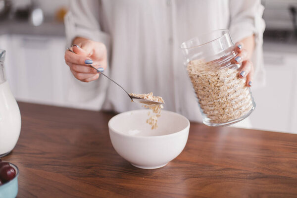 Красивая молодая женщина готовит завтрак на кухне
