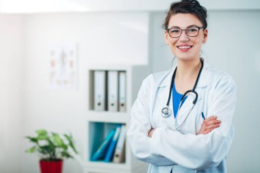 Kadın doktor steteskopla muayenehanesinde.