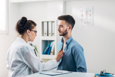 Hastanın doktor koğuşundaki hastaya göğüs kontrolü yapılıyor.