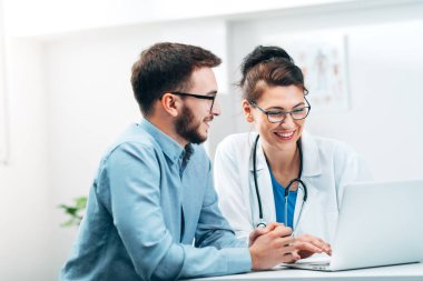 Hastane Laboratuvarındaki genç stajyer görevi tamamlar ve geri bildirim alır.