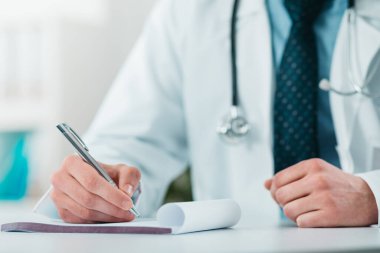 Genç Doktor 'a tanı yazarken yaklaş. Hastanedeki gönüllü, hastalıkların tedavisinde pratik bilgi kazanıyor