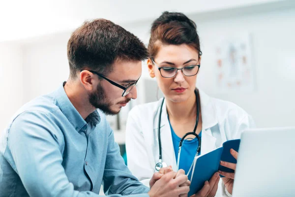 Médica Seu Consultório Médico Com Estetoscópio Lendo Resultados Para Paciente — Fotografia de Stock