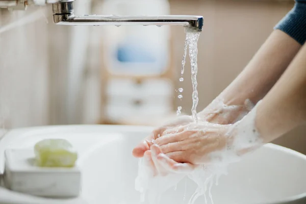 Covid 19のウイルス感染を防ぐために バスルームで手を洗う女性の閉鎖 コロナウイルスパンデミック時の石鹸と水道水での洗浄をお勧めします — ストック写真