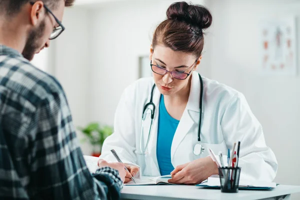 Kadın Doktor Hastalığını Tedavi Etmesi Için Genç Hastaya Ilaç Yazıyor — Stok fotoğraf