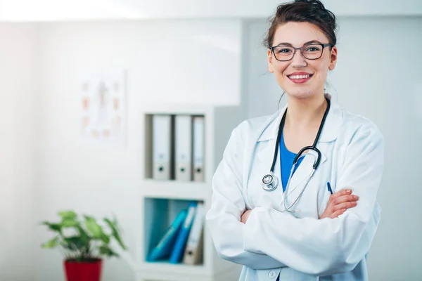 Kadın doktor steteskopla muayenehanesinde.