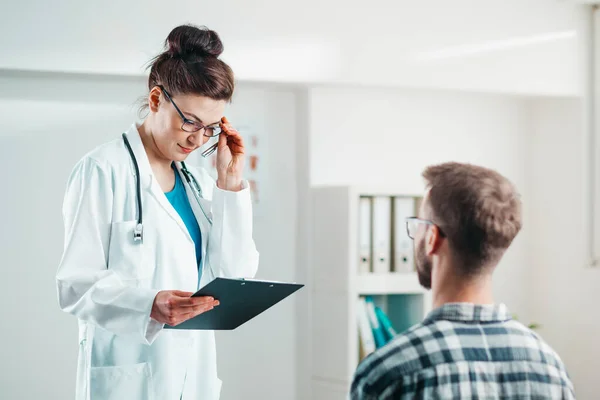 Kadın Doktor Hastalığını Tedavi Etmeden Önce Genç Hastaya Sonuçları Okur — Stok fotoğraf