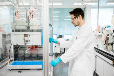 Kimyager, kovid 19 'u önlemek için koronavirüs aşısı üzerinde araştırma yapıyor. Modern bir tıp laboratuvarında kendini işine adamış bir bilim adamı..