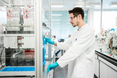 Kimyager, kovid 19 'u önlemek için koronavirüs aşısı üzerinde araştırma yapıyor. Modern bir tıp laboratuvarında kendini işine adamış bir bilim adamı..