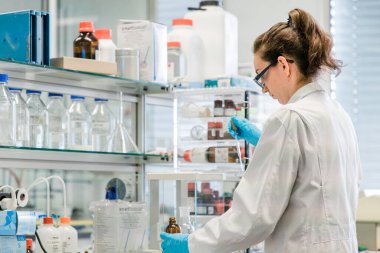 Kimyager, kovid 19 'u önlemek için koronavirüs aşısı üzerinde araştırma yapıyor. Modern bir tıp laboratuvarında kendini işine adamış bir bilim adamı..