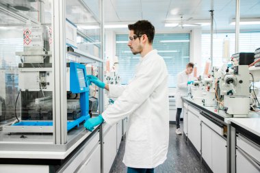 Kimyager, kovid 19 'u önlemek için koronavirüs aşısı üzerinde araştırma yapıyor. Modern bir tıp laboratuvarında kendini işine adamış bir bilim adamı..