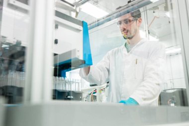 Kimyager, kovid 19 'u önlemek için koronavirüs aşısı üzerinde araştırma yapıyor. Modern bir tıp laboratuvarında kendini işine adamış bir bilim adamı..