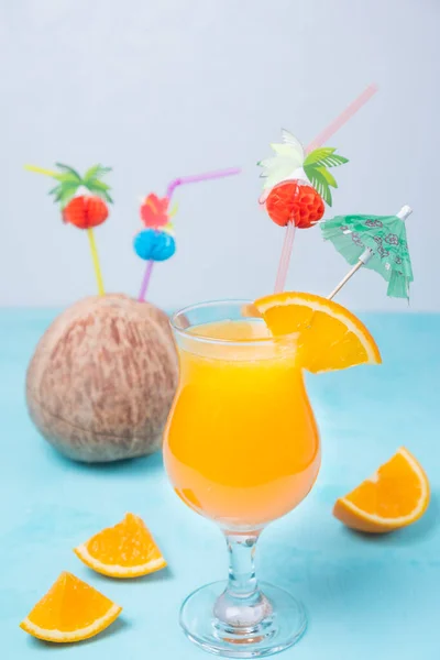 glass of orange juice, tropical cocktail on a turquoise background