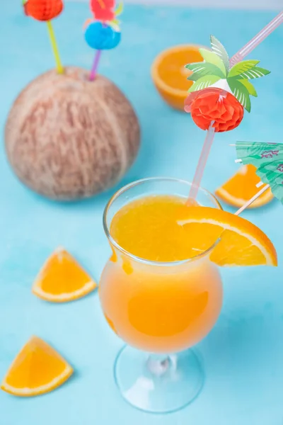 glass of orange juice, tropical cocktail on a turquoise background