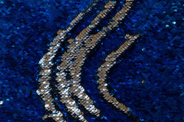 scratches of silver sequins on a background of blue shiny sequins
