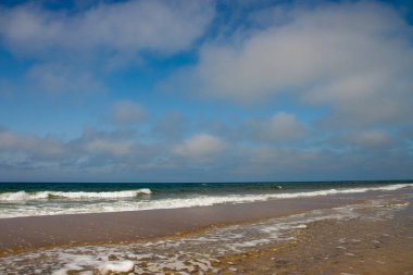 Deniz kenarında gündüz masmavi gökyüzü ve bulutlar