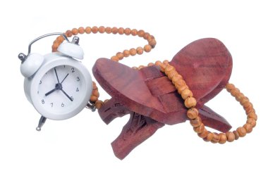 Alarm saati ve Tasbih veya Rehal veya Kuran ahşap kitap standındaki İslami dua boncukları.
