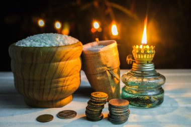 Yığınla para, hesap makinesi, gaz lambası ve pirinç ahşap arka planda. Zeka kavramı. Zekat, zenginlerden fakire pay edilmesidir..