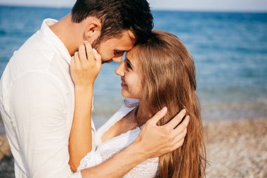 Kucaklayan ve gülümseyen sarılma sevgi sahil üzerinde mutlu genç Çift