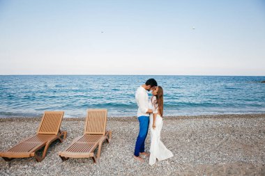 Kucaklayan ve gülümseyen sarılma sevgi sahil üzerinde mutlu genç Çift