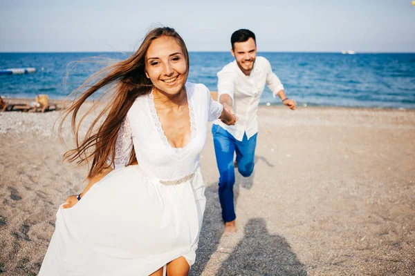 Kucaklayan ve gülümseyen sarılma sevgi sahil üzerinde mutlu genç Çift