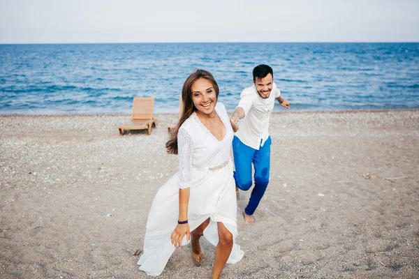 Feliz jovem casal na praia no amor abraçando e abraçando sorrindo — Fotografia de Stock