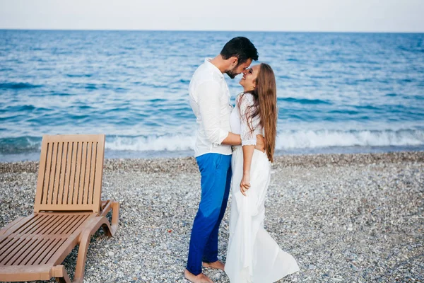 Felice giovane coppia sulla spiaggia in amore abbracciare e abbracciare sorridente — Foto Stock