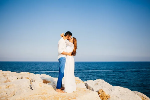 Felice giovane coppia sulla spiaggia in amore abbracciare e abbracciare sorridente — Foto Stock