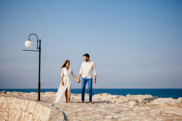 Feliz jovem casal na praia no amor abraçando e abraçando sorrindo — Fotografia de Stock