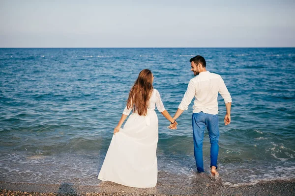 Feliz jovem casal na praia no amor abraçando e abraçando sorrindo — Fotografia de Stock