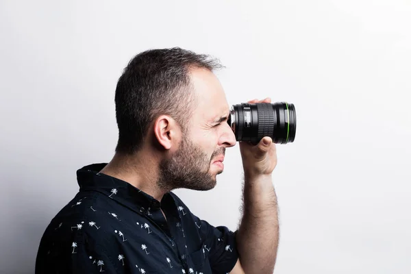 Homem barbudo olhando através da lente — Fotografia de Stock