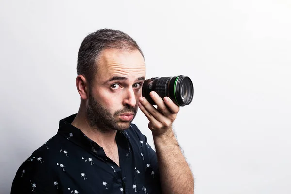 Uomo barbuto guardando attraverso lente — Foto Stock