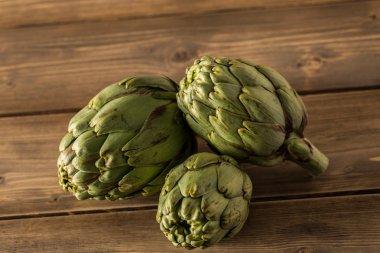 Rustik ahşap bir masa üzerinde doğal enginar.