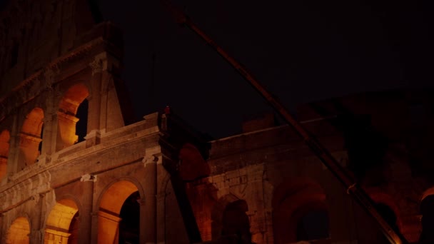 Roman Kolezyumu 'nda gece yeniden inşa çalışmaları. Karanlık gece gökyüzünde ışık saçan Roma amfi tiyatrosu var. — Stok video