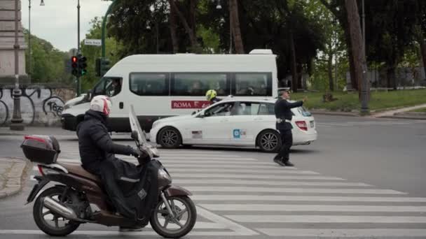 ROMA, ITALIA - 14 DE MAYO DE 2019: El policía de tránsito regula el tráfico de automóviles en la calle Via della Greca en Roma. Inspector de carretera — Vídeos de Stock