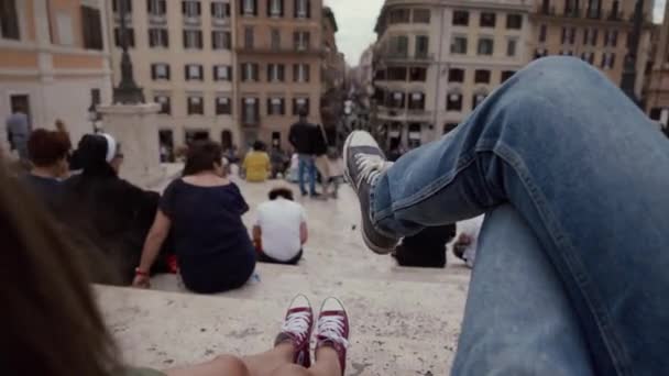 Рим, Італія - 14 травня 2019: Пара туристів у кольорових кросівках сидить на сходах Іспанських сходів. Рим, Італія. Відео сельфі знято згори. — стокове відео