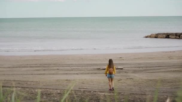 Vista trasera de la joven mujer disfrutando de vistas al mar viene al mar Mediterráneo. Vacaciones de viaje de mujer feliz con mochila — Vídeos de Stock