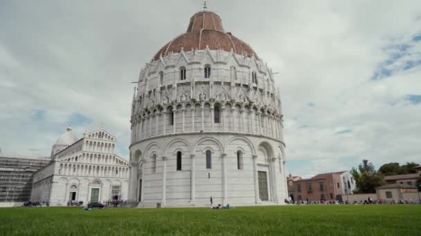 Mujer joven se divierte en el césped del Baptisterio de San Juan en la Plaza de los Milagros en Pisa Italia — Vídeos de Stock