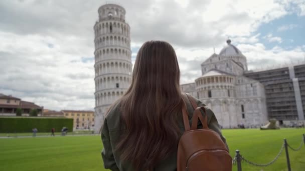 Widok z tyłu brunetki stojącej na Piazza dei Miracoli przed katedrą w Pizie i Krzywą Wieżą w Pizie, Włochy — Wideo stockowe