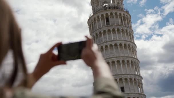 Tourist girl takes picture of Leaning Tower of Pisa using phone. Rear view — 图库视频影像