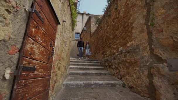 Mann mit einem Mädchen, das händchenhaltend die Treppe einer antiken Stadt in Italien hinuntergeht — Stockvideo