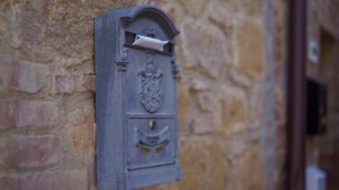 Vintage blue-grey ceramic mailbox with letter on old stone terracotta wall