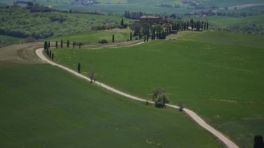 Scenic landscape with gladiator villa, road near Pienza. Endless green meadows