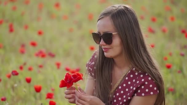 Mujer feliz en gafas de sol sostiene ramo de flores de amapola roja. Ramo de flores silvestres — Vídeo de stock