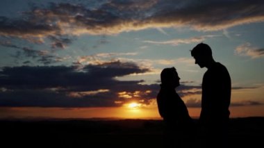 Incredible sunset with silhouettes of two people in love. Romantic atmosphere