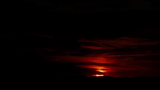 Sol dourado completamente ajustado sobre o horizonte no céu nublado escuro da noite vermelha — Vídeo de Stock