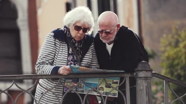 Wenecja, Włochy - 21 maja 2019: Osoby starsze w okularach przeciwsłonecznych stoją i czytają mapę — Wideo stockowe