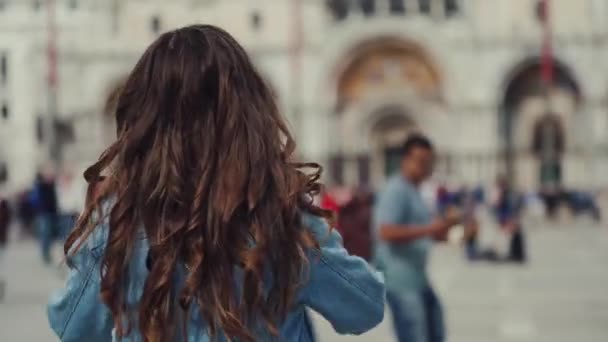 Brunette girl puts straw hat on head, turns around with smile, begins to whirl — Stock Video