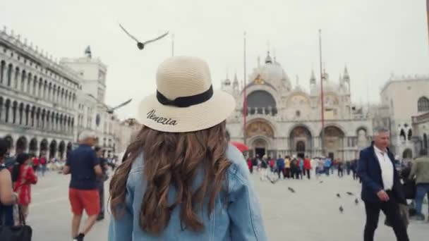 Venedig, Italien - 21 maj 2019: glad lockig kvinna på hattpromenader på San Marco-torget — Stockvideo